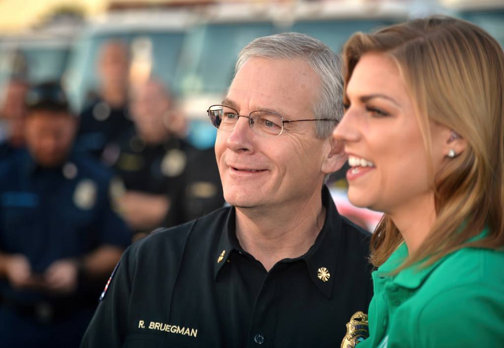 Anaheim Fire & Rescue Chief Randy Bruegman and Bri Winkler of ABC7 Eyewitness News as they get ready for a live TV interview for the Spark of Love Toy Drive at the Honda Center in Anaheim. Photo by Steven Georges/Behind the Badge OC