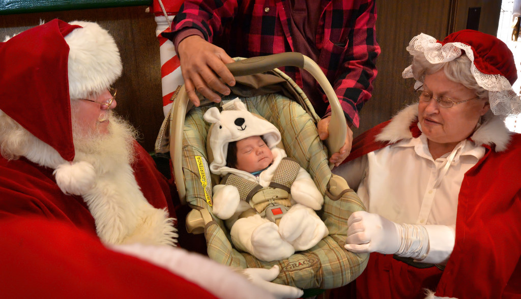 Santa and Mrs. Claus greet 5-week-old Emma Anaya as families get their turn with the Christmas couple during Fullerton PDÕs Adopt a Family breakfast at police headquarters. Photo by Steven Georges/Behind the Badge OC