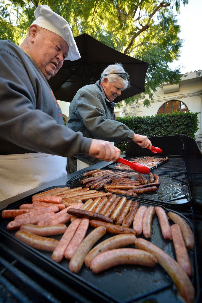 David Everitt, left, and Steve Zerga of Fullerton PDÕs RSVP, (Retired Senior Volunteers Program) grills up the pancakes, bacon and sausages for Fullerton PDÕs Adopt a Family breakfast at police headquarters. Photo by Steven Georges/Behind the Badge OC