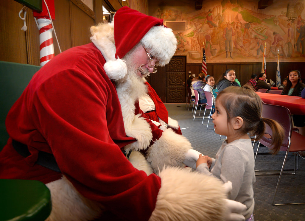Two-year-old Sophia Rivera walks up to talk to Santa during Fullerton PD’s Adopt a Family breakfast at police headquarters. Photo by Steven Georges/Behind the Badge OC