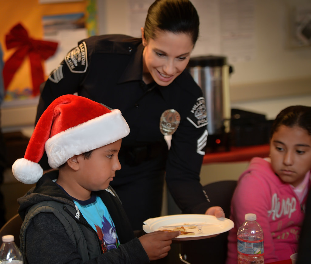 Nestor Anaya, 8, gets assistance from Fullerton PD’s Sgt. Kathryn Hamel during Fullerton PD’s Adopt a Family breakfast at police headquarters. Photo by Steven Georges/Behind the Badge OC