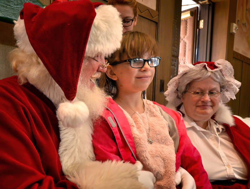 Isabella Werner, 7, gets her turn with Santa and Mrs. Claus during Fullerton PDÕs Adopt a Family breakfast at police headquarters. Photo by Steven Georges/Behind the Badge OC