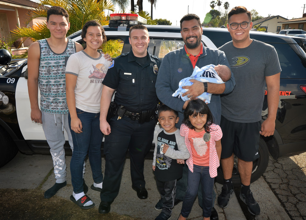 The Barragan family with Garden Grove PD Officer Mitchel Mosser, including Luis Barragan holding his 3-week-old son Gabriel Barragan, and his two kids in front of him Matthew Barragan, 3, and Emily Barragan, 5. The kids mom, Erika, passed away three weeks ago the day after giving birth to Gabriel. Photo by Steven Georges/Behind the Badge OC