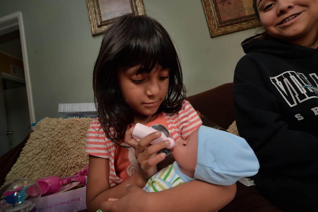 Emily Barragan, 5, feeds her new doll she named Aerial that was given to her as a Christmas present from Garden Grove PD officers after her mother, Erika, passed away three weeks ago. Photo by Steven Georges/Behind the Badge OC