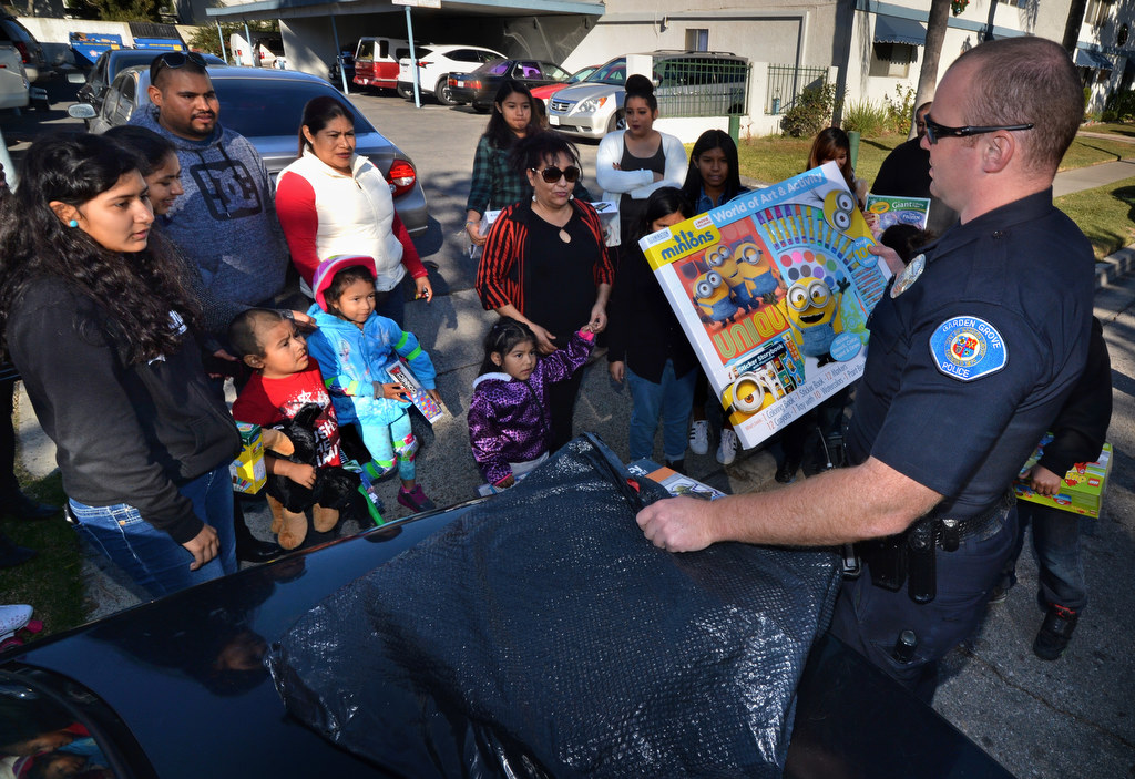 Garden Grove PD Officer Nick Lazenby hands out presents to the kids in the Sunswept Ave. neighborhood on Christmas day. The presents were donated by officers and employees of Garden Grove PD. Photo by Steven Georges/Behind the Badge OC