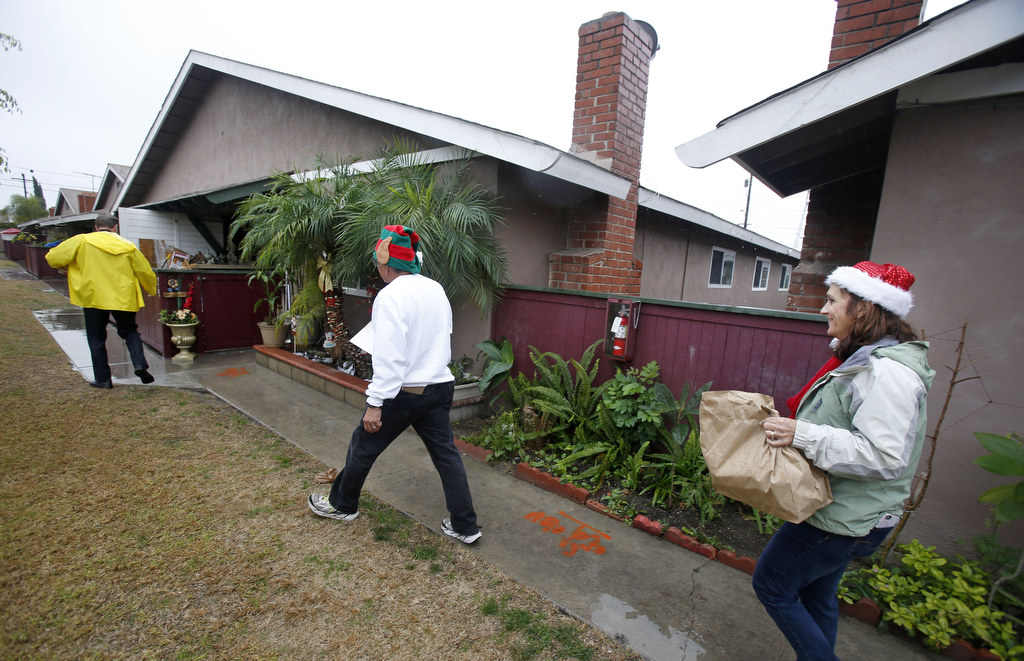 Captain Jarrett Young, retired Captain Joe Vargas and Jennifer Vargas, from left, bring gifts for children in Anaheim for the Christmas holiday. The Anaheim Police department distributed Christmas gifts and food to needy families in the community. Photo by Christine Cotter/Behind the Badge OC