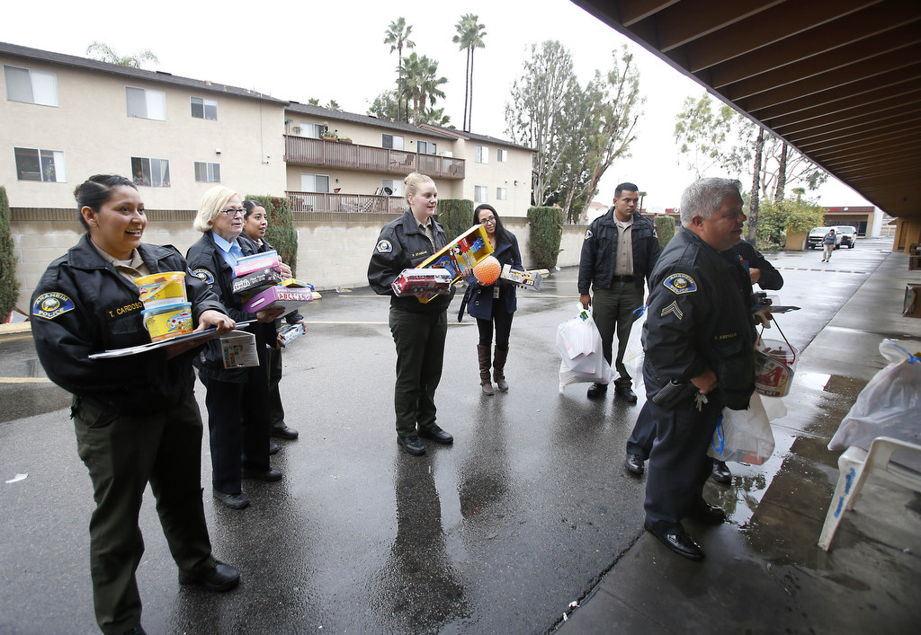 Members of the Anaheim Police Department and volunteers deliver Christmas gifts to families living at a local motel. The police department distributed Christmas gifts and food to needy families in the community. Photo by Christine Cotter/Behind the Badge OC