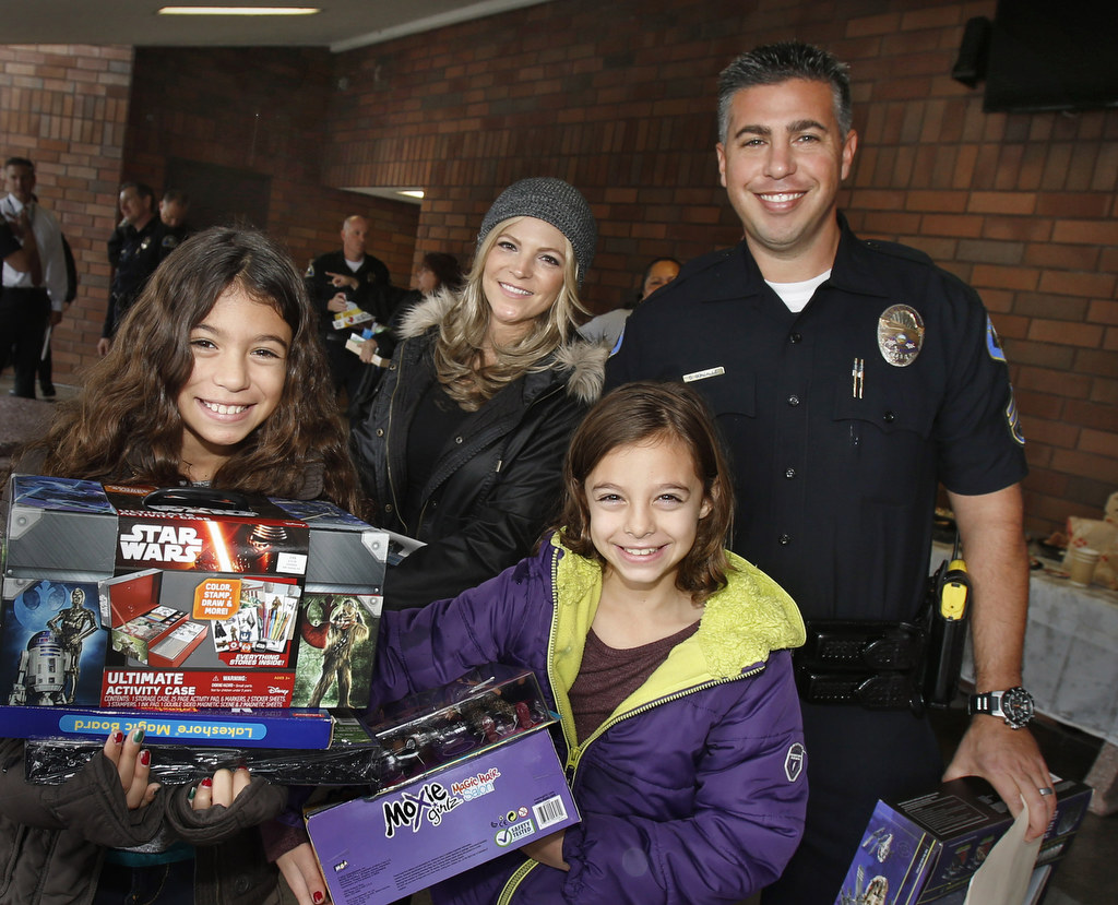 Anaheim Police Sgt. Daniel Gonzalez, wife Mary and daughters, Faith,10, and Allison, 8, helped distribute Christmas gifts and food to needy families in Anaheim. Photo by Christine Cotter/Behind the Badge OC