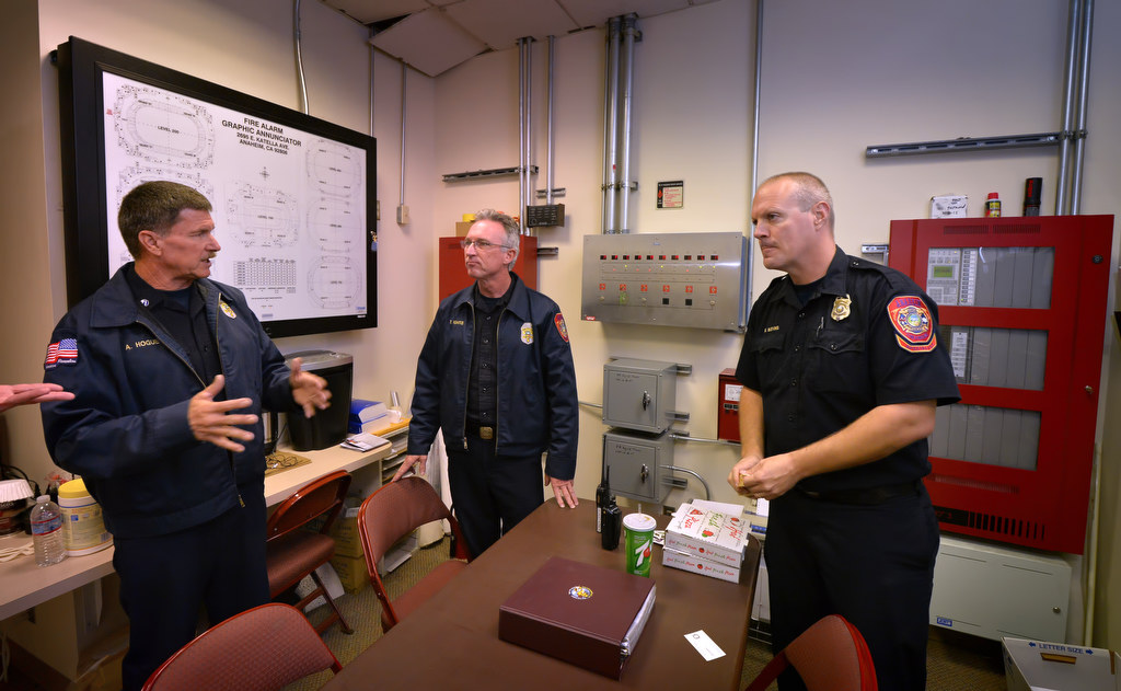 Allen Hogue, assistant fire marshal for Anaheim Fire & Rescue, left, talks to Todd Rudaitis, AF&R inspector, and Gary Blevins, AF&R hazardous materials specialist II, inside the control room at the Honda Center before a Ducks game. Photo by Steven Georges/Behind the Badge OC