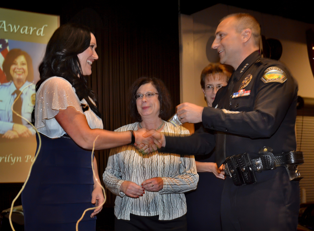 Police Services Officer Megan Evans, left, receives the Community Service Award from Tustin Police Chief Charles Celano. Also on stage receiving the Community Service Award is Marilyn Packer and Adriana Tokar. Photo by Steven Georges/Behind the Badge OC