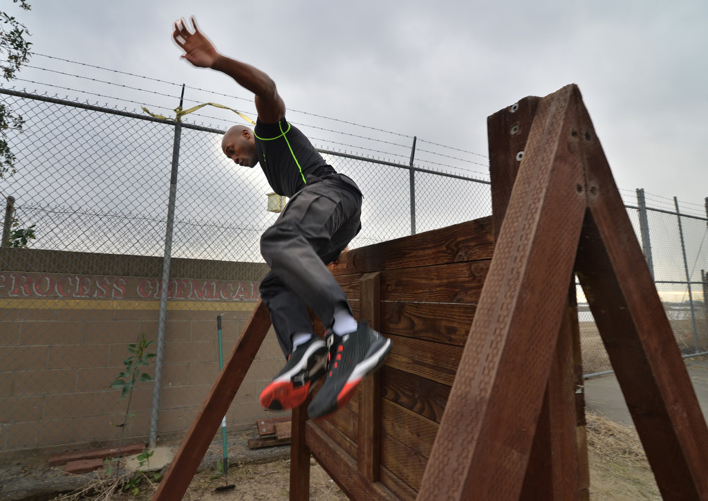 Anaheim PD Officer Sheddi Skeete climbs over a wall as part of an exhausting timed obstacle course. Photo by Steven Georges/Behind the Badge OC