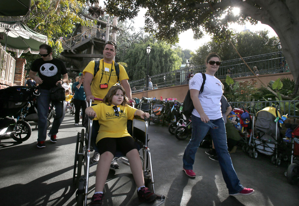 Kaitlin Cone is treated to a day at Disneyland with help from Patrick Barton, left, and Laura Rauschmayer, a volunteer from the Orange County Sheriff's Department. The OC Sheriff's and Canada's Sunshine DreamLift made the day special for children with disabilities and serious illnesses. Photo by Christine Cotter