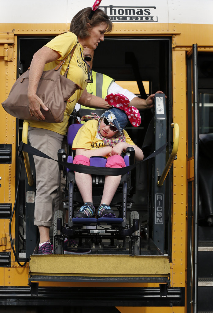 Nine year-old Emilie D'Arcy is helped off the bus by Barbara Semmelink on her first trip to Disneyland. The OC Sheriff's and Canada's Sunshine DreamLift made it a special day for children with disabilities and serious illnesses. Photo by Christine Cotter