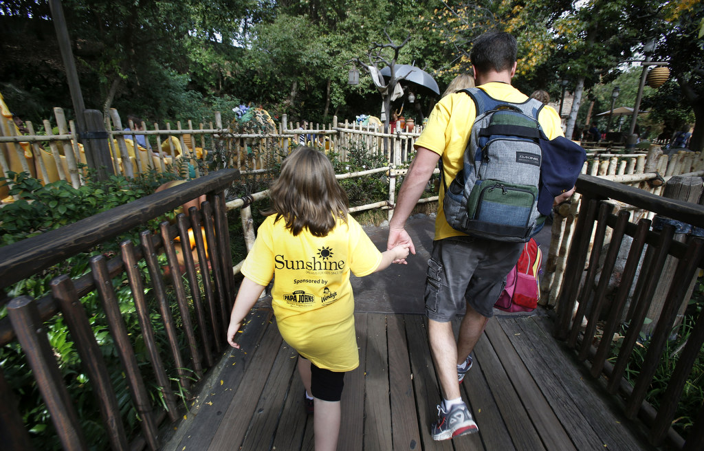 Patrick Barton and Kaitlin Cone walk hand in hand during a daylong visit to Disneyland as part of the Orange County Sheriff's Department 's efforts to help children with disabilities and serious illnesses.  Photo by Christine Cotter