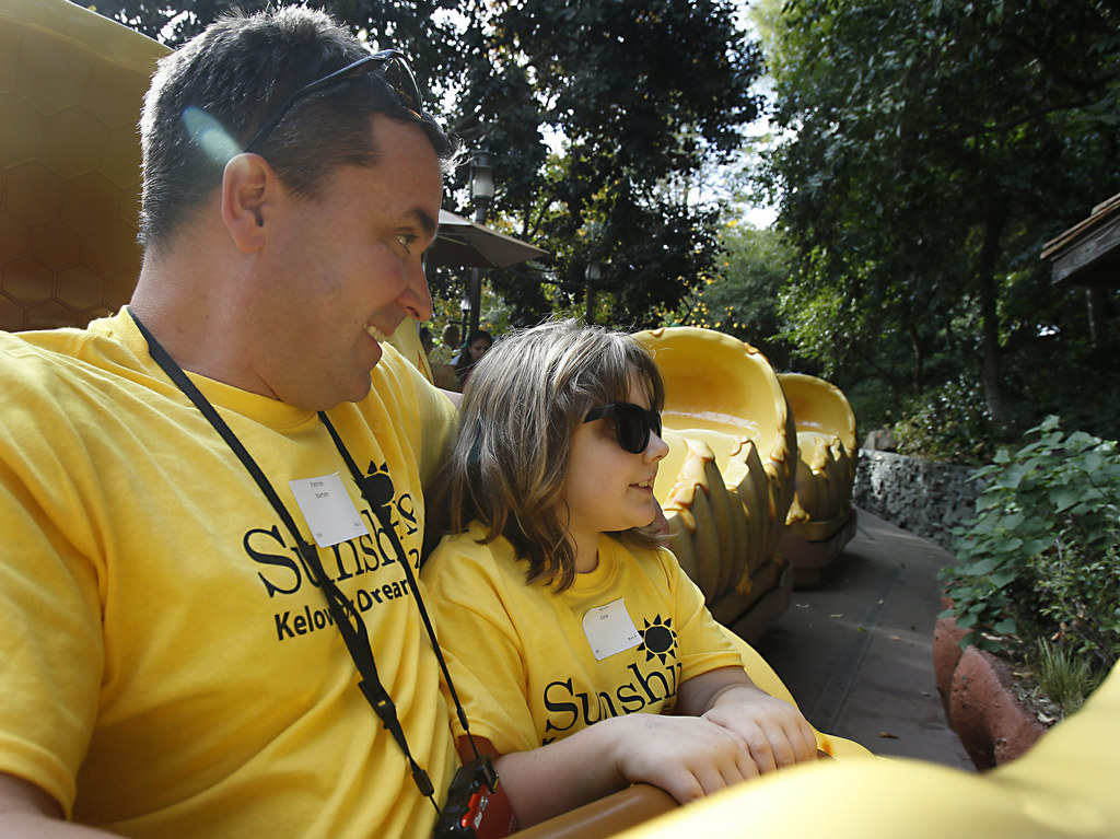 Patrick Barton and Kaitlin Cone take a spin on "The Many Adventures of Winnie the Pooh" during a daylong visit to Disneyland as part of the Orange County Sheriff's Department 's efforts to help children with disabilities and serious illnesses.  Photo by Christine Cotter