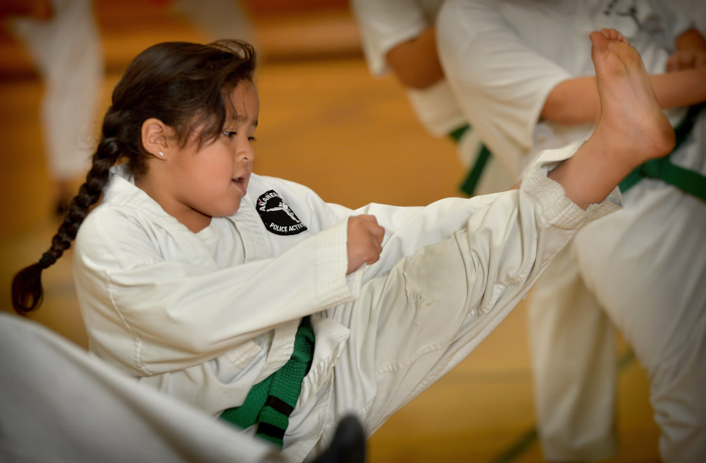 Six-year-old Caylee Castro runs through her kick exercises during a Anaheim Police Activities League/Cops 4 Kids karate class. Photo by Steven Georges/Behind the Badge OC