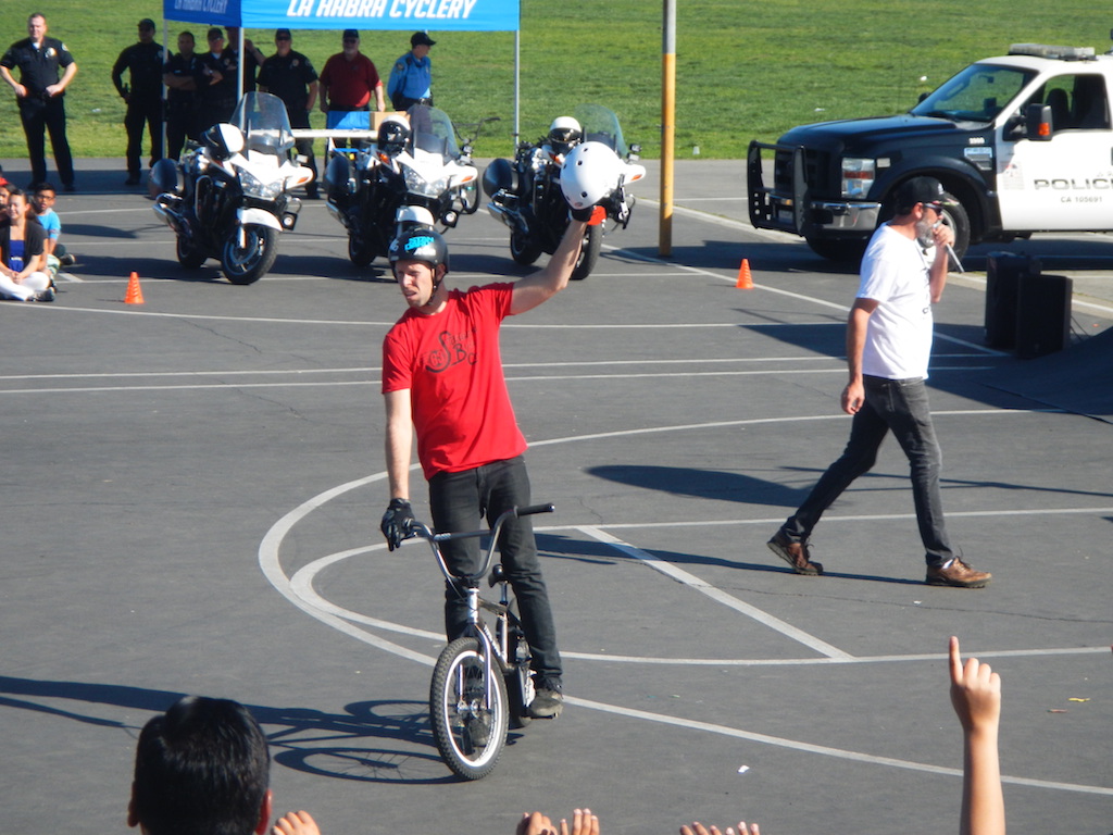 Professional BMX Rider Joey Cordova hands out a helmet at Imperial Middle School as part of a bike safety demonstration. Photo by Sgt. Jim Tigner/La Habra PD 