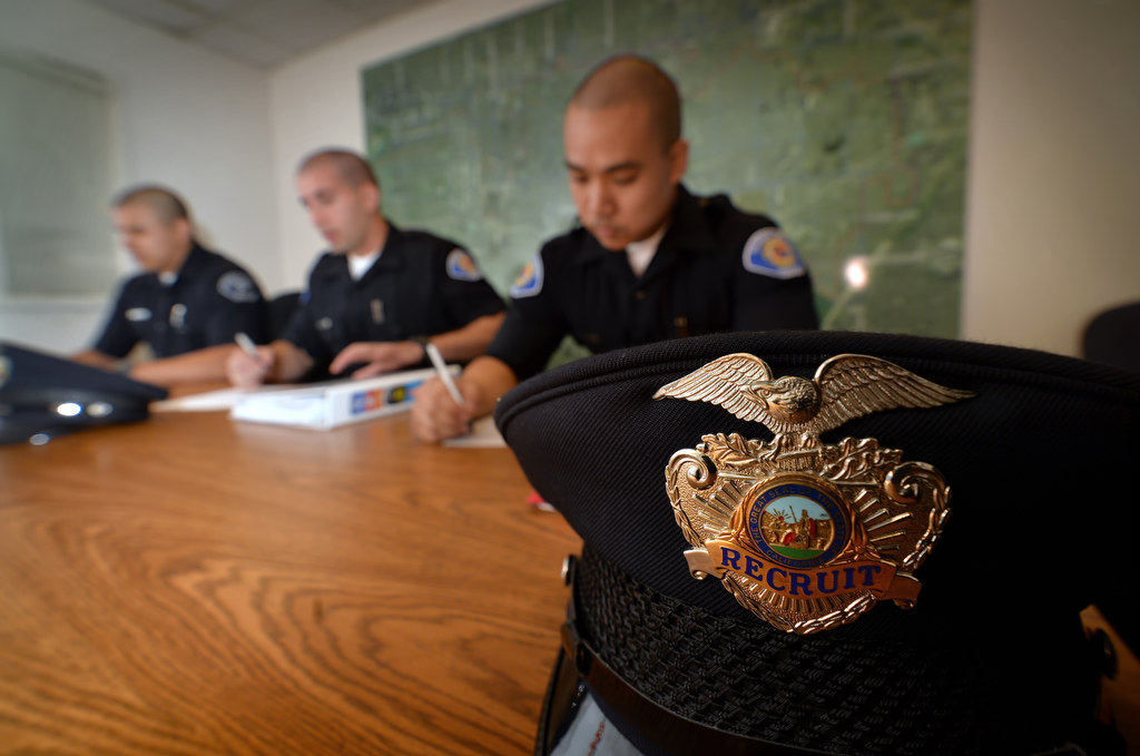 Buena Park PD Recruit Oscar Munoz, left, and Garden Grove PD Recruits Josh Behzad and Phillip Pham, right, sit down for a test on police codes after a drill session at GGPD. Photo by Steven Georges/Behind the Badge OC