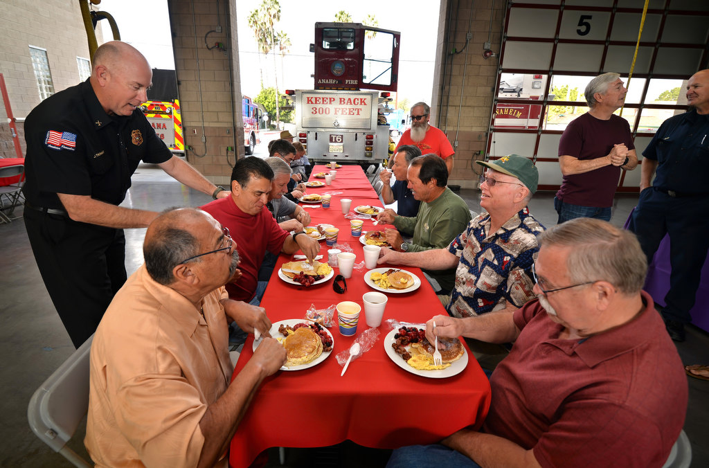 Anaheim Fire & Rescue Battalion Chief Jeff Thomas, standing left, greets friends during the department’s annual retiree breakfast at Fire Station 6. Photo by Steven Georges/Behind the Badge OC