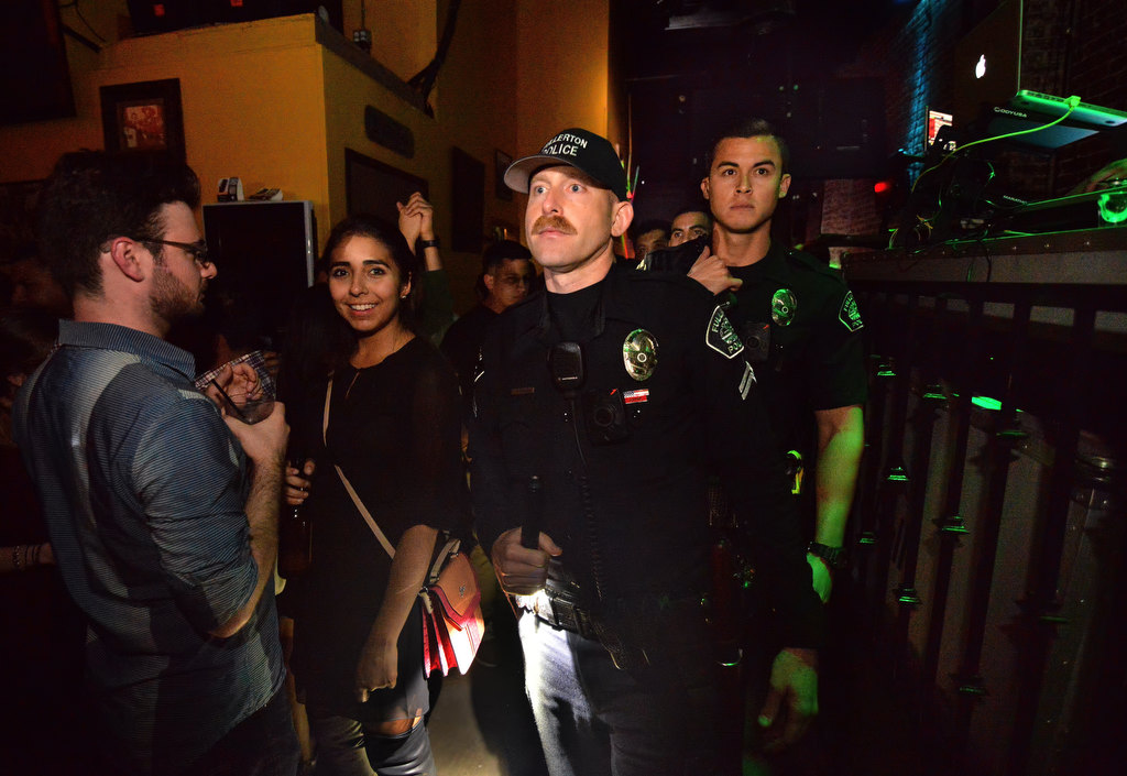 With the cooperation of the Revolution Mexican Grill & Cantina, Fullerton PD’s Cpl. Ryan O’Neil, front, and Officer Davis Crabtree walk through the downtown Fullerton bar. Photo by Steven Georges/Behind the Badge OC