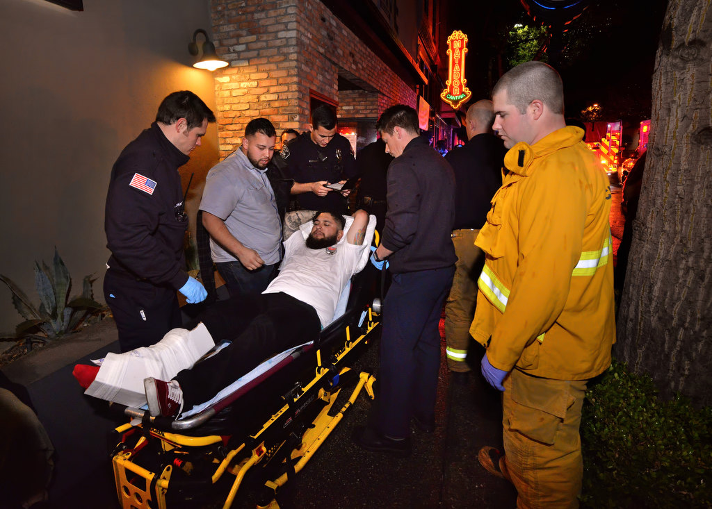 As Fullerton PD help direct foot traffic, Fullerton Fire paramedics tend to and prepare for transport a patent who broke his ankle after an altercation on Harbor Blvd. in downtown Fullerton (in front of Fuoco Pizzeria Napoletana) early Sunday morning. Photo by Steven Georges/Behind the Badge OC