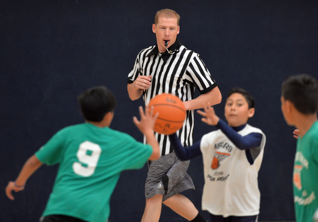 Cpl. Scott Gump of the Westminster PD runs with the kids as he referees the Hoops Championship basketball game. Photo by Steven Georges/Behind the Badge OC