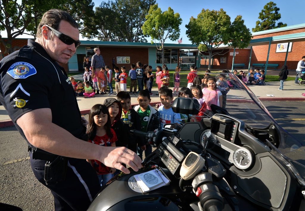 Kids from Anderson Elementary School in Garden Grove line up as Garden Grove Motorcycle Officer Tom Capps shows them his police motorcycle during a visit by the PD to talk about bicycle safety. Photo by Steven Georges/Behind the Badge OC