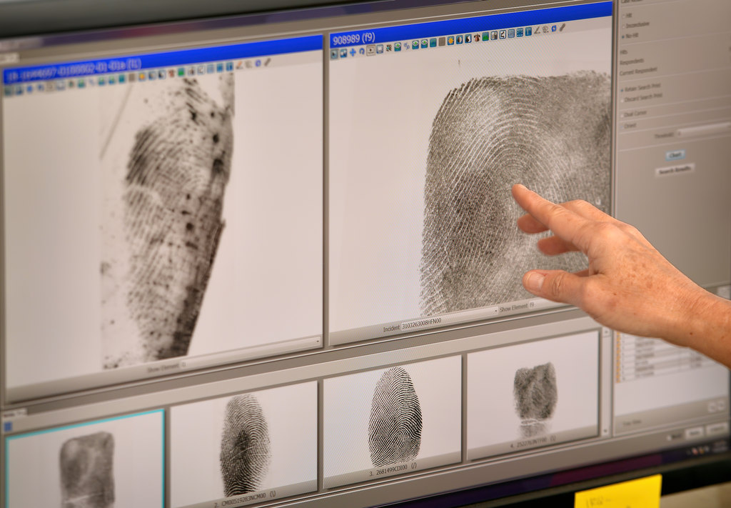 Debbie Mele, lead forensic specialist, shows how a partial print, left, that would have been unusable in the past before computers and special software, can now reveal enough information to help identify a suspect. Photo by Steven Georges/Behind the Badge OC