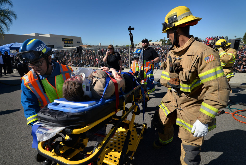 Rescue crews take a simulated injured passenger to a waiting ambulance during a staged drunk driving accident in front of Anaheim High School. Photo by Steven Georges/Behind the Badge OC