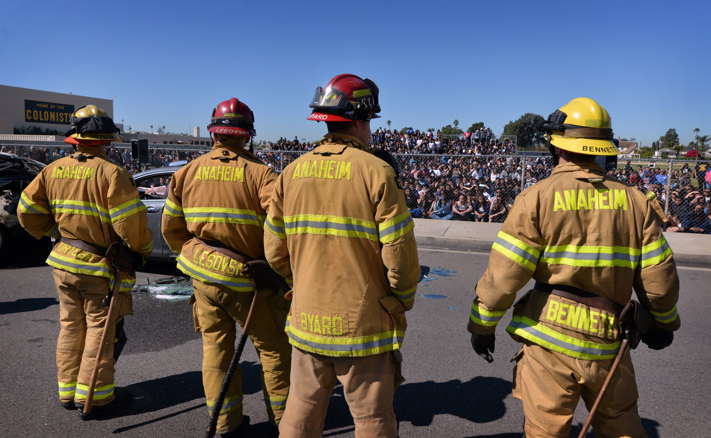 Anaheim Fire & Rescue firefighters, Ortega, left, Capt. John Lesovsky, Capt. Mike Byard and Jamison Bennett take one last look at the students at the end of a staged drunk driving accident in front of Anaheim High School. Photo by Steven Georges/Behind the Badge OC