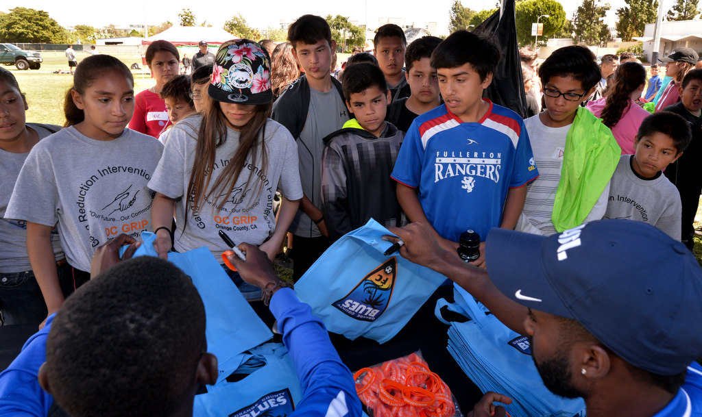 Players from the Orange County Blues FC soccer team autographs shirts for kids lined up during the OC GRIP soccer camp at Cal State Fullerton. Photo by Steven Georges/Behind the Badge OC