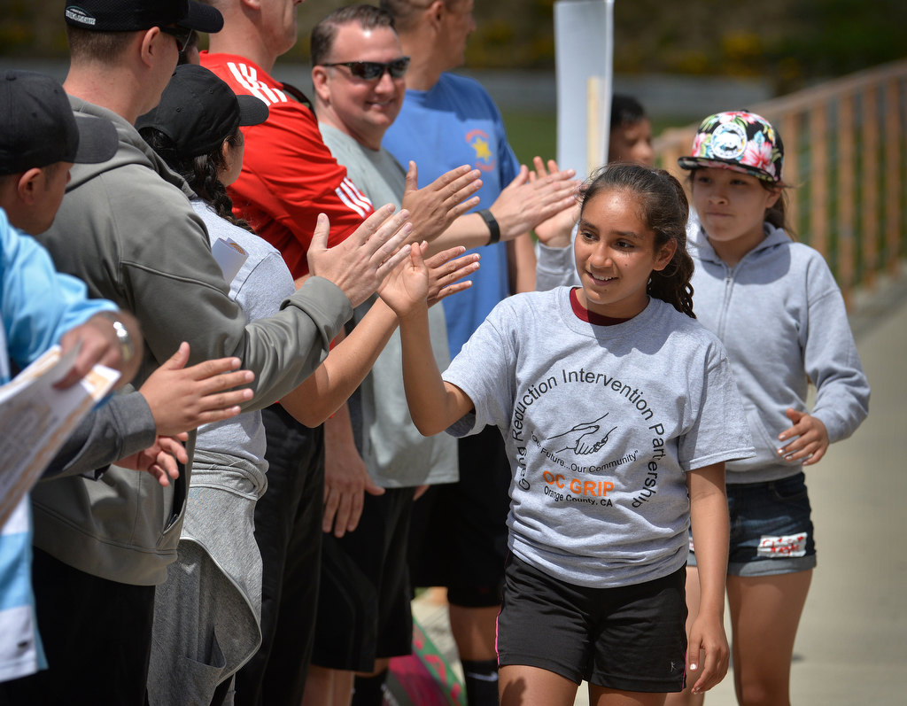 Jasmin Sandoval receives high-fives from coaches and police dignitaries as the kids who participated in the OC GRIP soccer camp at Cal State Fullerton are recognized. Photo by Steven Georges/Behind the Badge OC