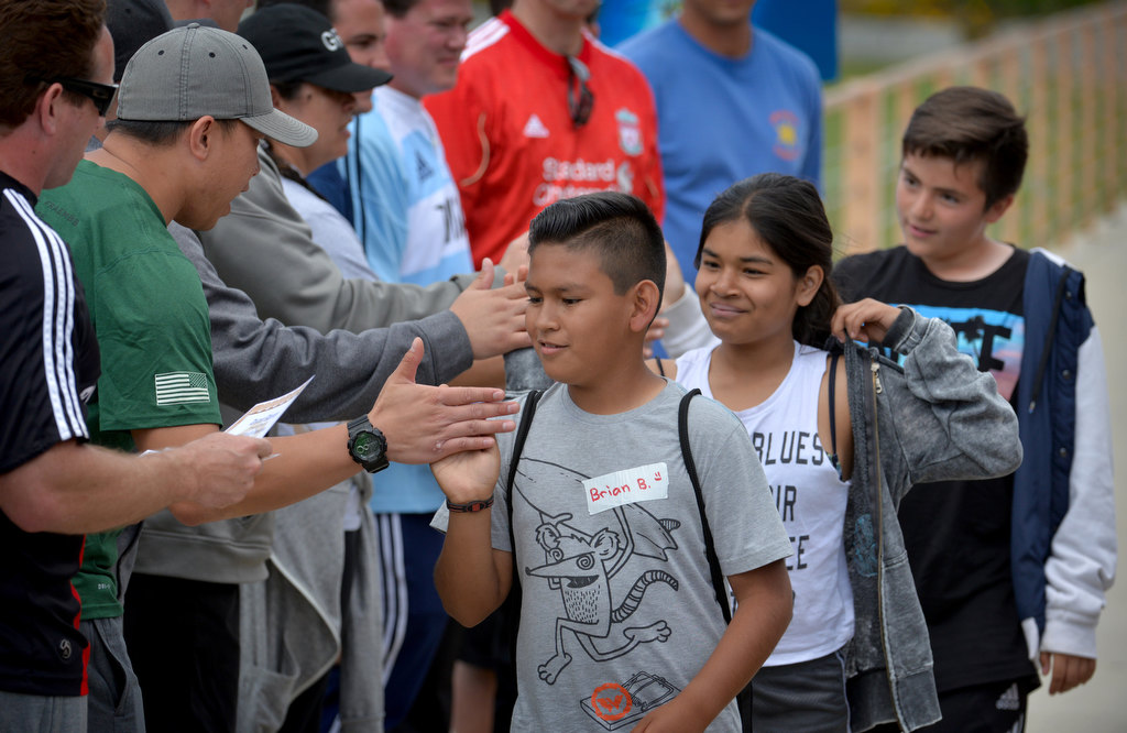 Kids get high-fives from coaches and police dignitaries as the kids who participated in the OC GRIP soccer camp at Cal State Fullerton are recognized. Photo by Steven Georges/Behind the Badge OC