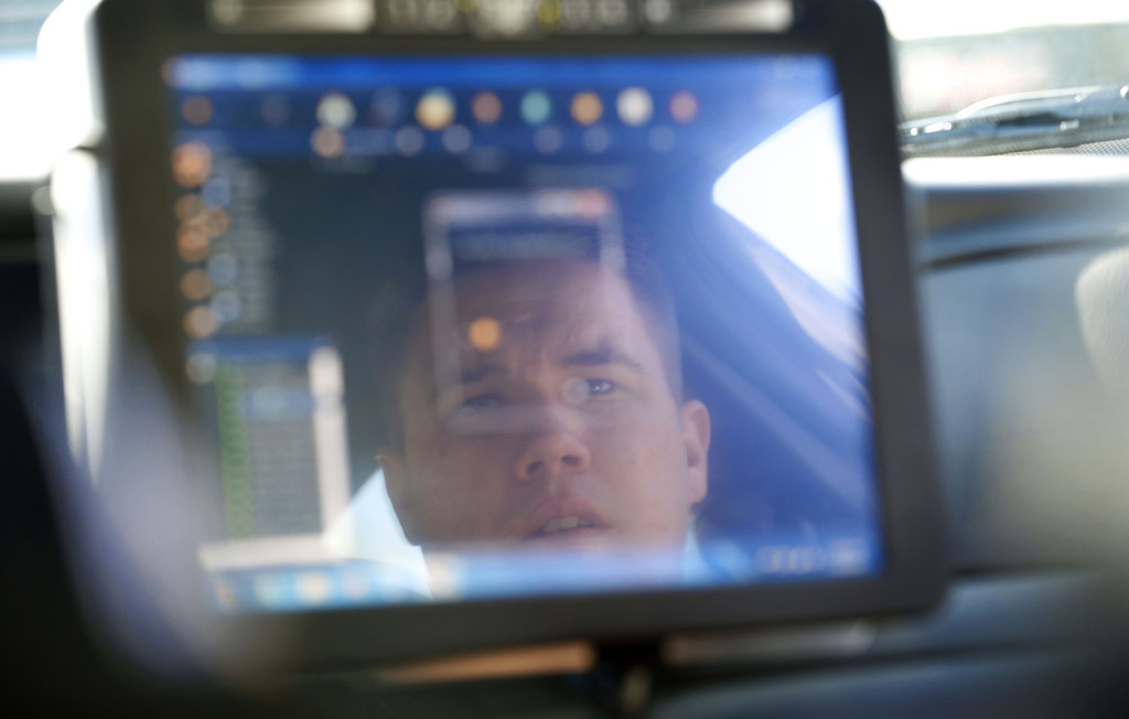 Garden Grove Police Officer Danny Mihalik is reflected in the computer screen of a squad car during the department's undercover alcohol purchase sting. Photo by Christine Cotter