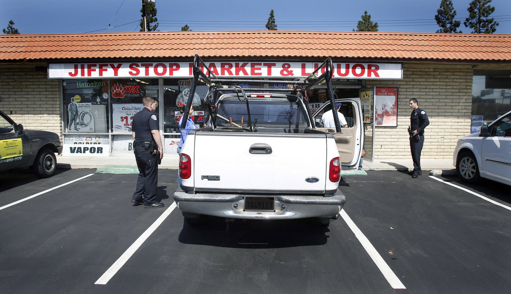 Garden Grove Police Officer Danny Mihalik, left and  Officer Austin Laverty approach a suspect during Operation Shoulder Tap, an undercover alcohol purchase sting. Photo by Christine Cotter