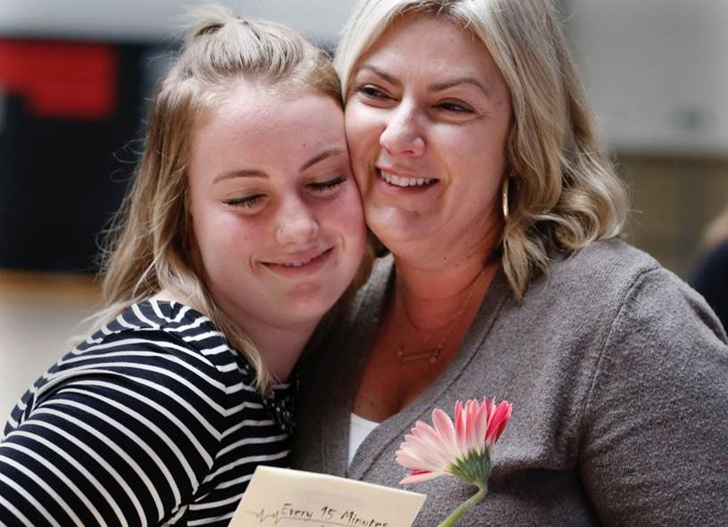 Nicole Andreae hugs her mom after the final assembly in the Every 15 Minutes Program. Andreae played the suspect in Tustin High School's event. Photo by Christine Cotter/Behind the Badge OC. 