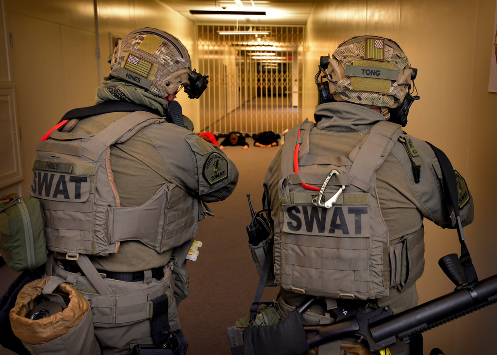 North County SWAT officers Sgt. Michael Hines, left, and Officer Cary Tong of Fullerton PD secure a hallway with acting students at Sonora High School during an active shooter drill. Photo by Steven Georges/Behind the Badge OC