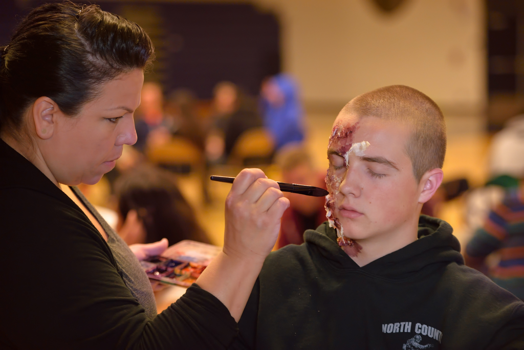 Lead makeup artist Denise Chavez paints the simulated injuries to the face of Dylan Marshall, an explorer from Brea PD, before the start of an active shooter drill at Sonora High School. Photo by Steven Georges/Behind the Badge OC