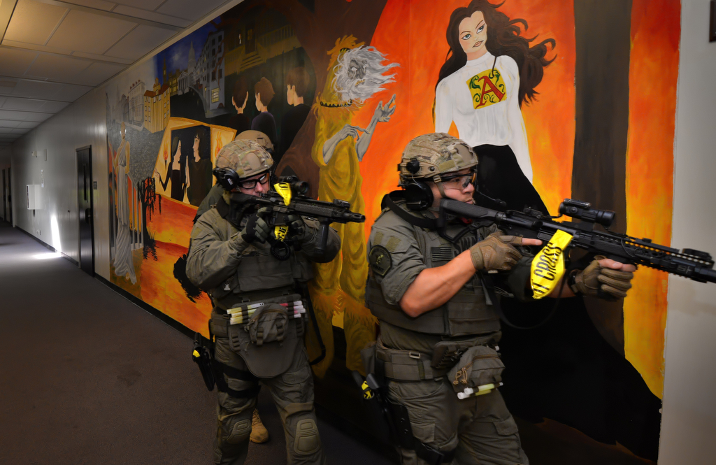 North County SWAT officers walk down the hallway of Sonora High School as they clear room after room during an active shooter drill. The yellow tape on the guns signifies that they have been checked and cleared to carry as an unloaded weapon. Photo by Steven Georges/Behind the Badge OC