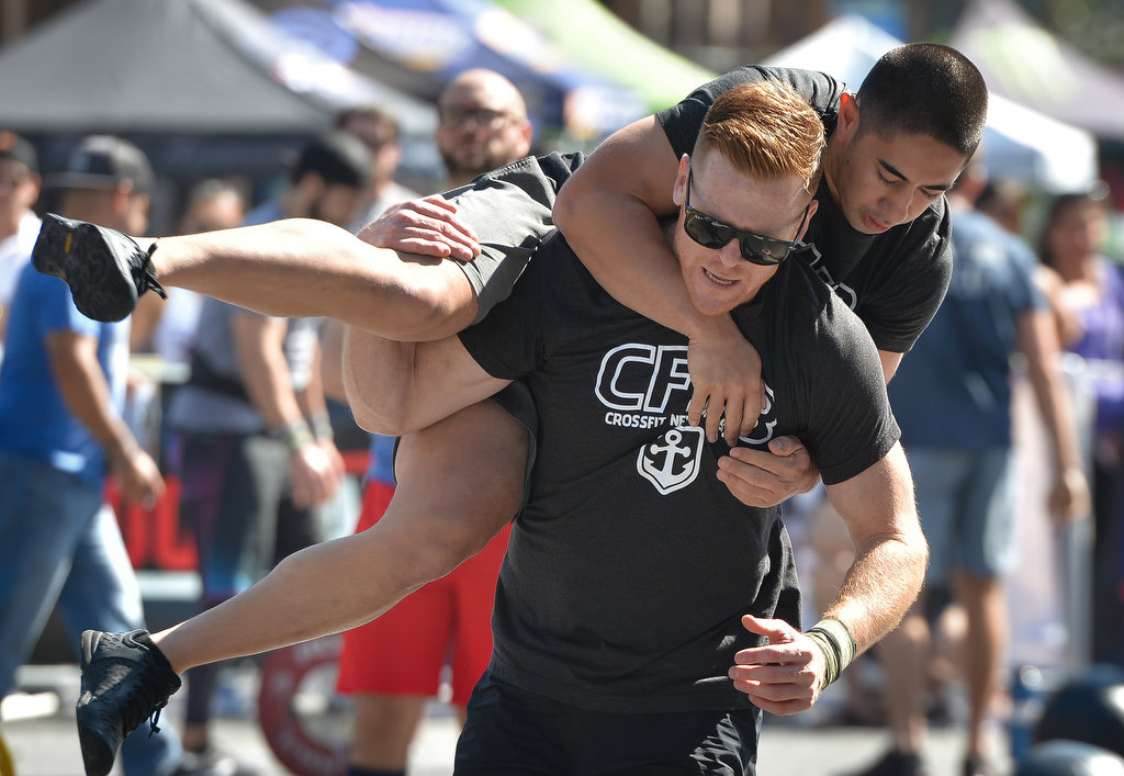 Manny Adams of Anaheim Fire & Rescue’s team Rookie and the WannaB carries Calvin Bui during the 2nd Annual APD Guns N Hoses Fitness Competition. Photo by Steven Georges/Behind the Badge OC
