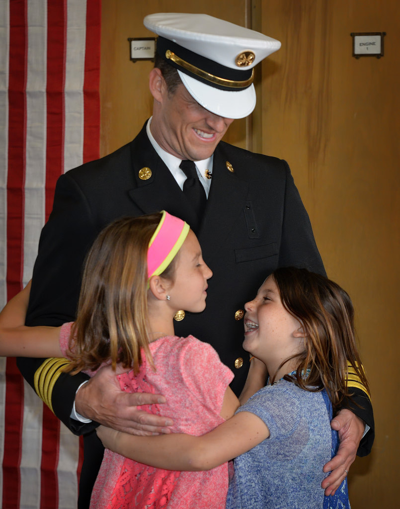 Fullerton/Brea Deputy Chief, Operations, Adam Loeser gets a big hug from his family just before receiving his new badge during the Fullerton Fire Department’s promotional ceremony. Photo by Steven Georges/Behind the Badge OC