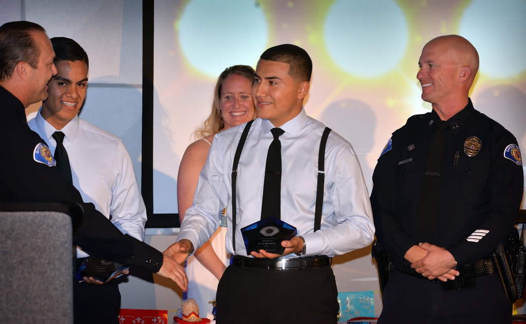 Jason Brito, center left, and Luis Quiroz receive the Top Honors award presented to them by Capt. Kevin Boddy, left, and Capt. Travis Whitman during the Garden Grove Police Explorers awards banquet. GGPD’s Kari Flood in behind them. Quiroz also received the Most Improved award. Photo by Steven Georges/Behind the Badge OC