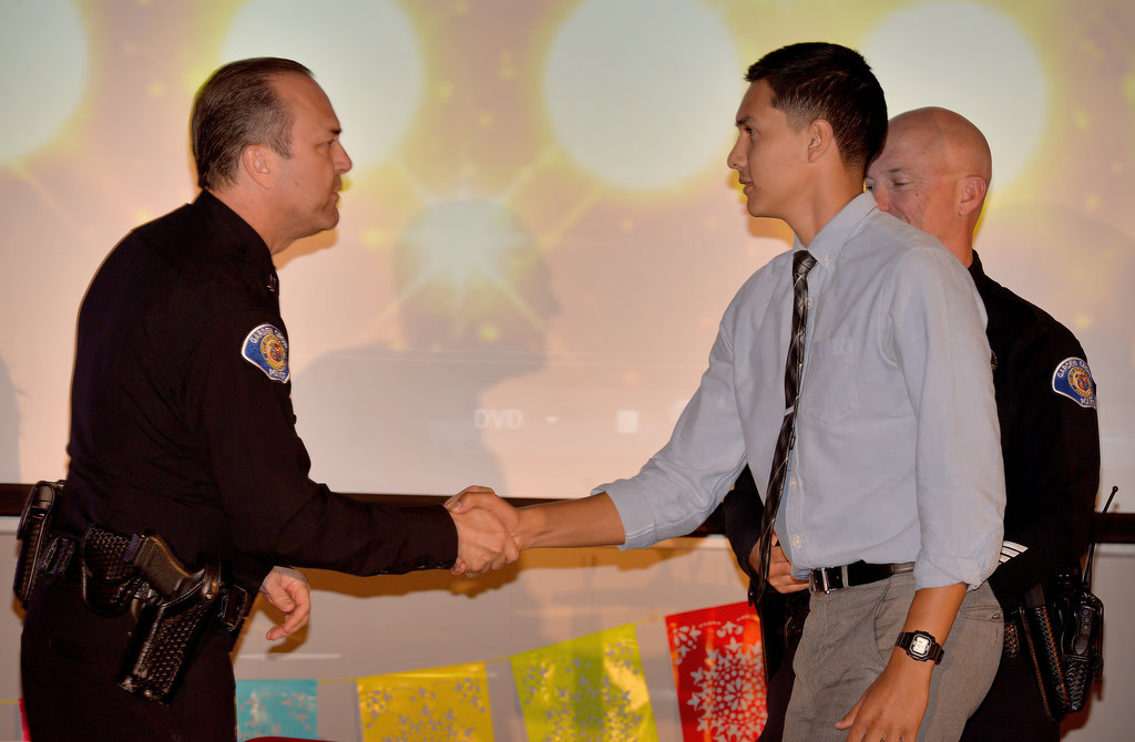 Garden Grove PD Explorer Daniel Alvarez, accepts the Most Inspirational award from Capt. Kevin Boddy, and Capt. Travis Whitman, behind him during the Garden Grove Police Explorers awards banquet. Alvarez also received the Explorer of the Year and Supervisor of the Year awards. Photo by Steven Georges/Behind the Badge OC