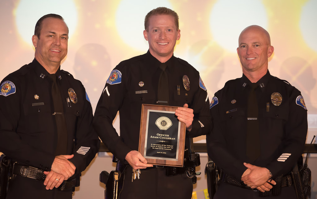 Officer Adam Coughran, center, receives an appreciation award for his “service to Explorer Post 1020 and the youth of the community now that he is moving on from Capt. Kevin Boddy, left and Capt. Travis Whitman. Photo by Steven Georges/Behind the Badge OC