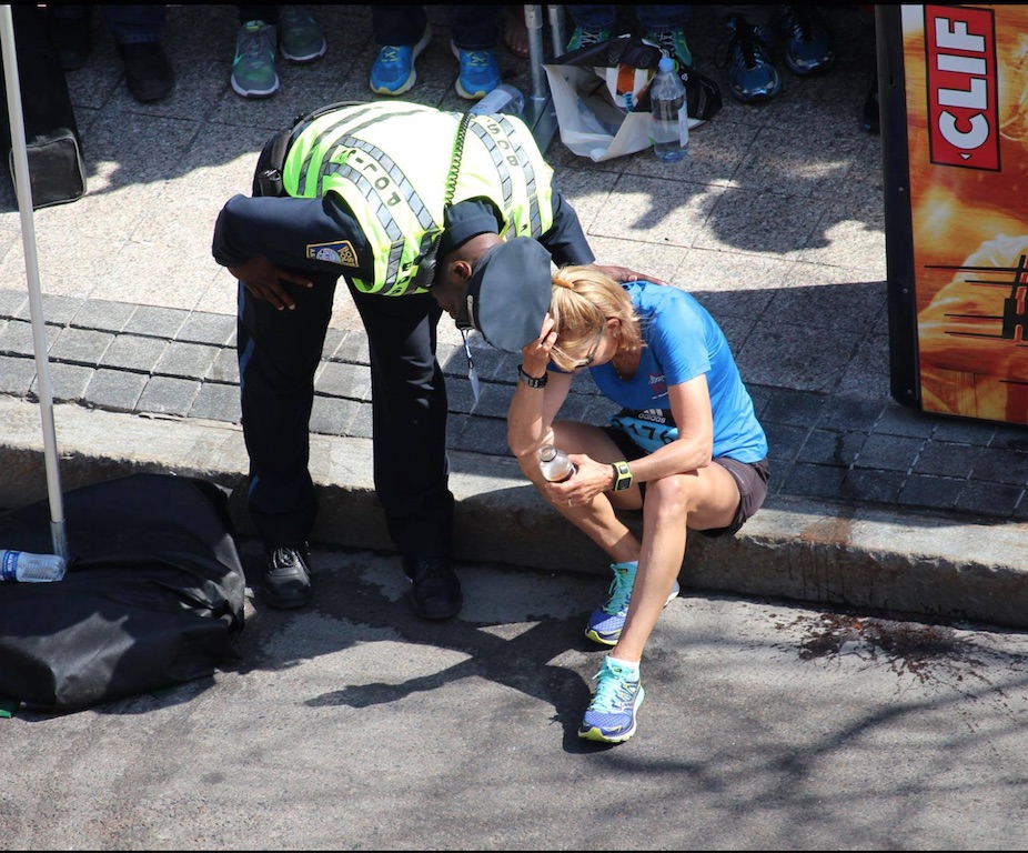 A Boston Police Officer encourages a tired runner to finish the Boston Marathon Monday. Photo from the Boston PD Facebook page. 
