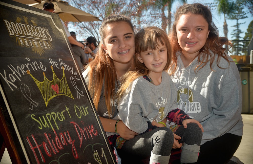 Six-year-old Katherine King, center, who was diagnosed with Diffuse Pontine Intrinsic Glioma (DIPG), an inoperable and incurable brain stem tumor, with her sisters Alissa LaShorne, left, and Tori LaShorne at Bootlegger’s Brewery and the Clothes for the Cause fundraiser. Photo by Steven Georges/Behind the Badge OC