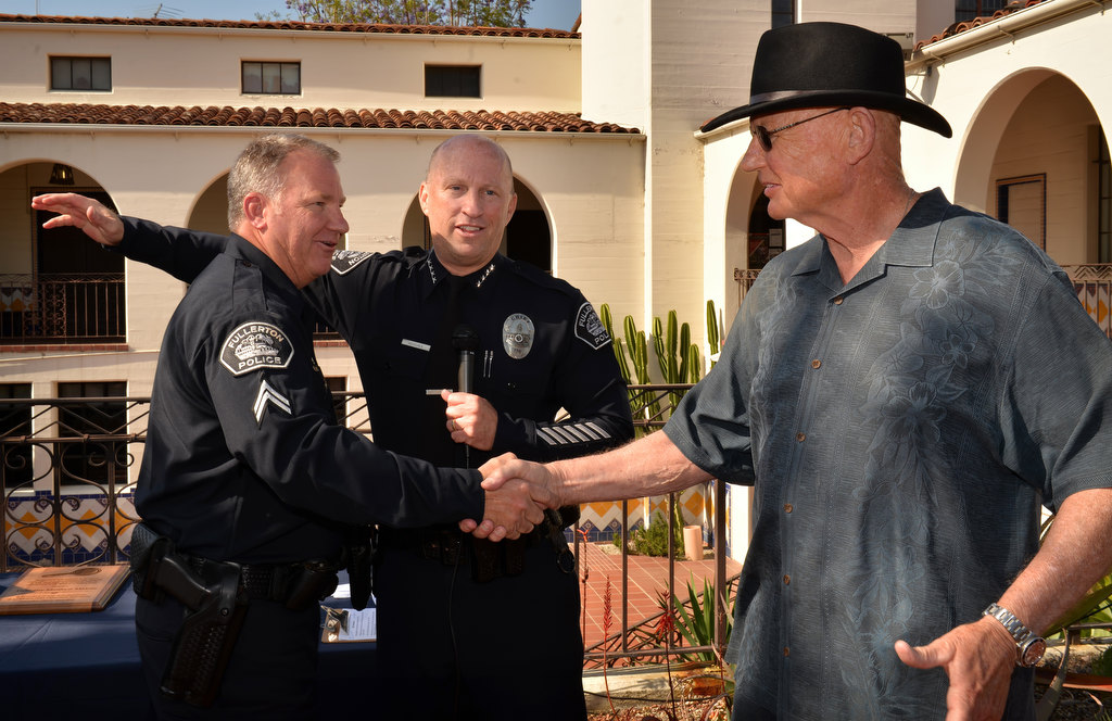 Fullerton PD Cpl. Matt Malone, left, is honored by Chief Dan Hughes and former Fullerton Police Chief Patrick McKinley (1993-2009), right, during Malone’s retirement ceremony. Photo by Steven Georges/Behind the Badge OC