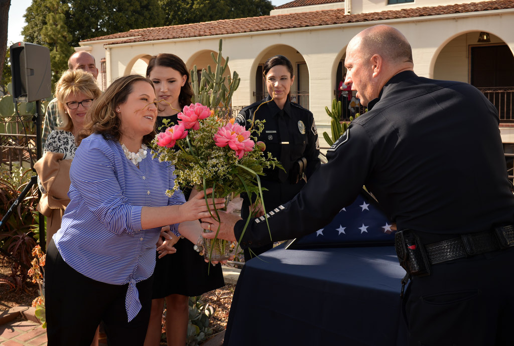 xxx, Cpl. Matt Malone’s wife, receives flowers from Fullerton Police Chief Dan Hughes during her husband’s retirement ceremony. Photo by Steven Georges/Behind the Badge OC