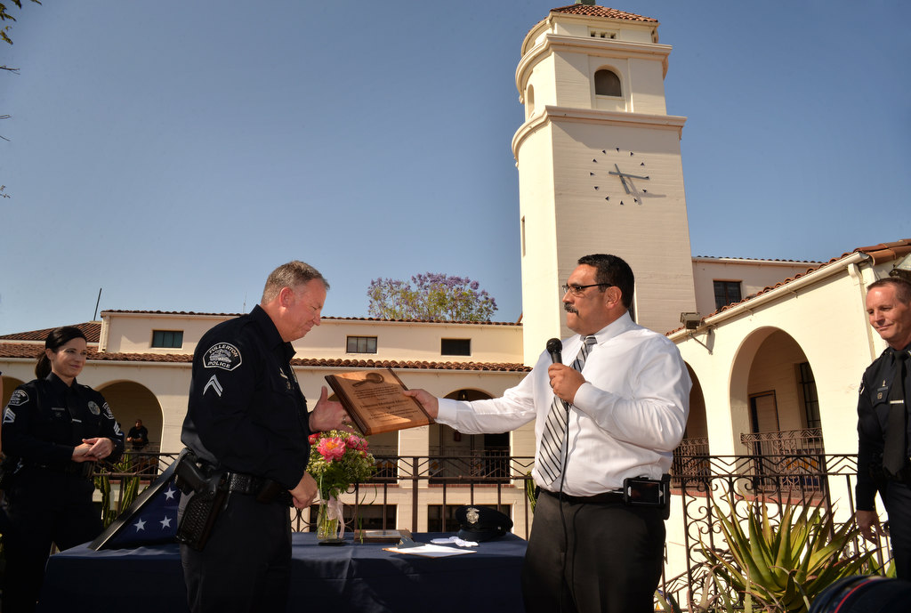 Fullerton PD Cpl. Matt Malone receives a plaque for his dedication and services from his friend and colleague xxxx during Malone’s retirement ceremony. Photo by Steven Georges/Behind the Badge OC