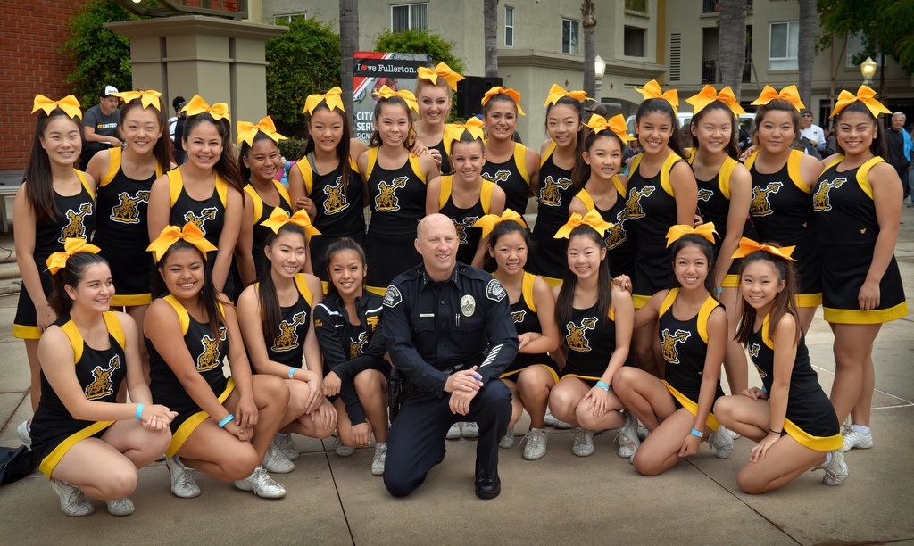 Fullerton Police Chief Dan Hughes, an alumni of Sunny Hills High, gathers with the Sunny Hills High Cheer team during the opening rally of Love Fullerton at Fullerton’s downtown plaza. Photo by Steven Georges/Behind the Badge OC